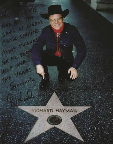 BRIGHT STAR: Richard Hayman died on Feb. 5 at the age of 93 after being a Local 802 member since 1953. At left, Mr. Hayman visits the Hollywood Walk of Fame, where he was awarded his own star in 1960. The inscription on the photograph is to Local 802’s Steve Danenberg, and it reads: “To Steve and all the gang at Wedo’s Music Service. Many thanks for all your help over the years. Sincerely, Richard.” Allegro printed a formal obituary for Mr. Hayman in the March issue.