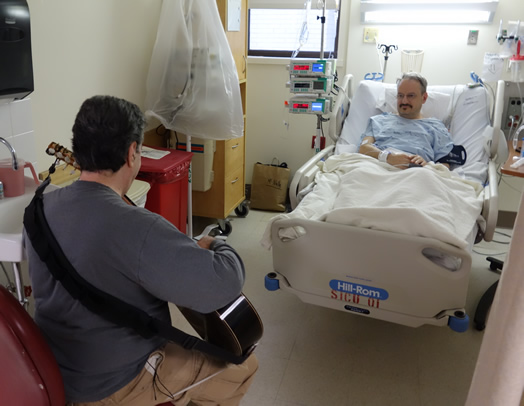 MUSIC HEALS: Andrew Schulman plays for a patient in the Surgical Intensive Care Unit at Beth Israel Hospital. Photo: Josh Aronson