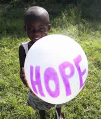 Rose, a Ugandan child, in the grass near her boarding school.