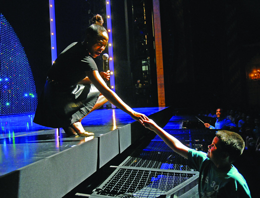 As part of the outreach program called "Creating the Magic," kids get to meet professional actors and musicians, including officers from Local 802. Above, Dionne Figgins in the role of Diana Ross from "Motown: the Musical" reaches out from the stage to a young audience member as conductor Joseph Joubert looks on. Photo: Steve Singer