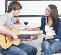 couple playing music guitar kitchen xavierarnau istock