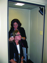 A special soundproof room helps audiologists test the hearing of musicians and other patients. Above, the audiologist is adjusting the headphones prior to the hearing test.