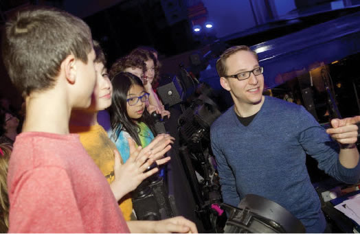 THE MAGIC OF MUSIC: Kids get excited about live musical theatre thanks to a program called Creating the Magic, produced by Inside Broadway. Above, Local 802 member and conductor John Bell shows the orchestra pit for "On the Town" at the Lyric Theatre.