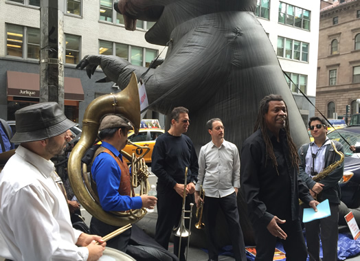 PAY THE MUSICIANS: Earlier this year, French film company KIDAM recorded 27 bands at the Winter Jazzfest to appear on Mezzo TV. To date, those bands have not been paid their full wages and benefits. Above, musicians rallied in early October in front of Mezzo's corporate owners, the Lagardere company, on Madison Ave. In front, bass legend Melvin Gibbs addresses the crowd. Gibbs is also the president of the Content Creators Coalition. For more info and to help, see www.justiceforjazzartists.org.