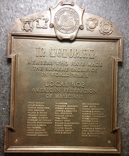 WE REMEMBER: This historic bronze plaque recognizes our members who gave their lives in World War II. As we reported previously in these pages, the plaque was lost when Local 802 moved from its previous site at Roseland to our current building. The plaque was eventually salvaged from a junkyard in Florida. Local 802 attorney Harvey Mars arranged (and paid) for its eventual return home. Please come and view the plaque in our lobby, just before you enter the club room.