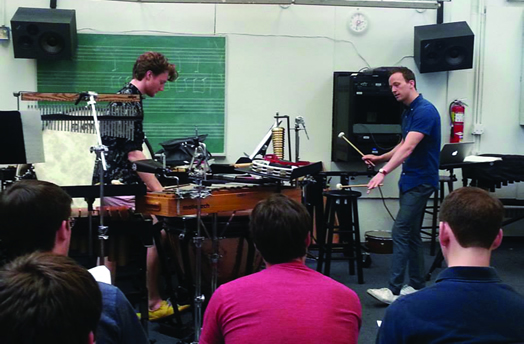 STUDENTS GET TO KNOW THE PROS: Andrew Adams (left) learns from Sean Ritenauer, percussionist from "Something Rotten."
